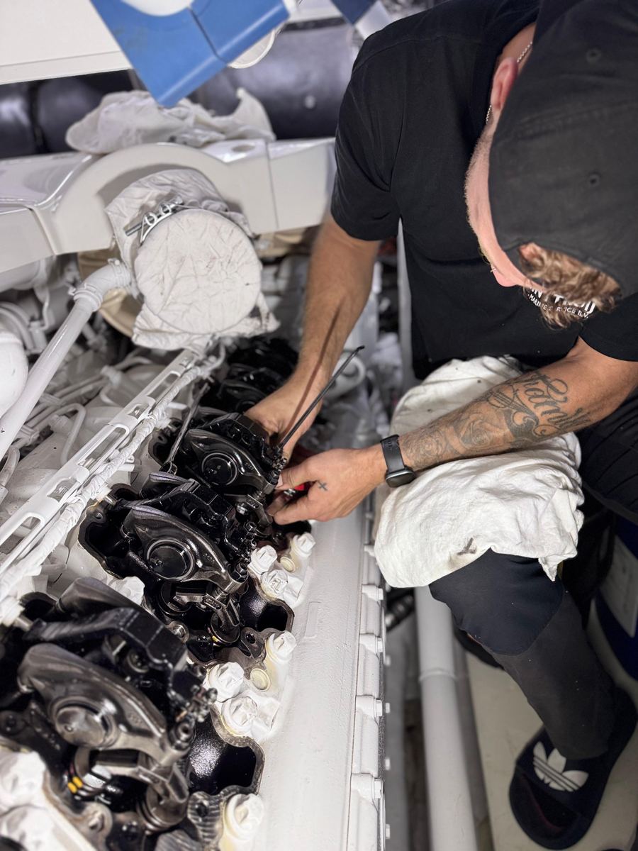 Marine diesel engineer carrying out a cylinder head overhaul on a superyacht engine